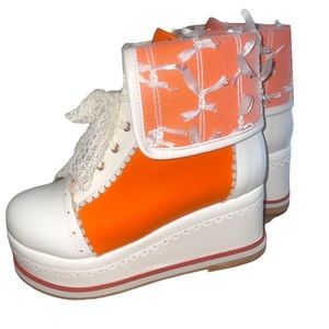 Size 6.5 orange and white platform boots with lace ties.